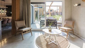 Un soggiorno moderno con zona pranzo, ampie porte scorrevoli in vetro che danno su un balcone e vista sulla città.