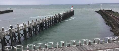 A pier extending into calm waters with a wooden walkway and railings.