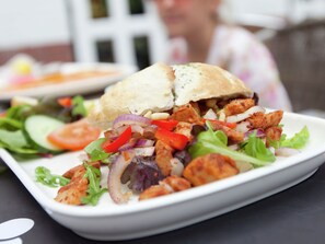 Un piatto con un panino e un'insalata.