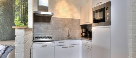 A modern kitchen with white cabinetry, a stainless steel stove, and a built-in microwave.