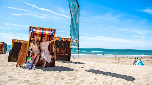 A beach scene with two beach chairs and a flag. - Neat Chalet With Microwave Near the Beach in Egmond (Egmond aan den Hoef)