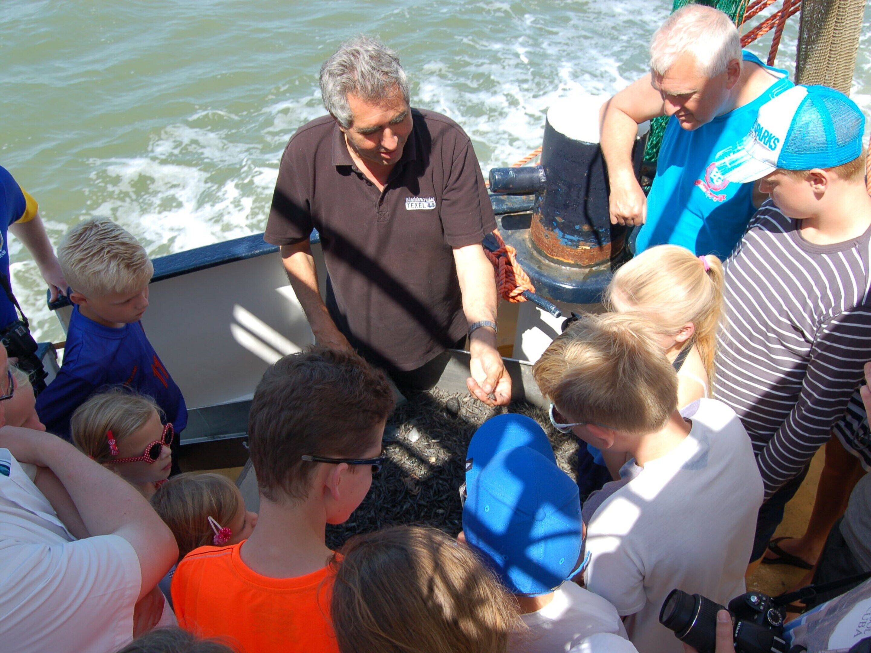A group of people on a boat with a man in a brown shirt and a woman in a blue shirt.