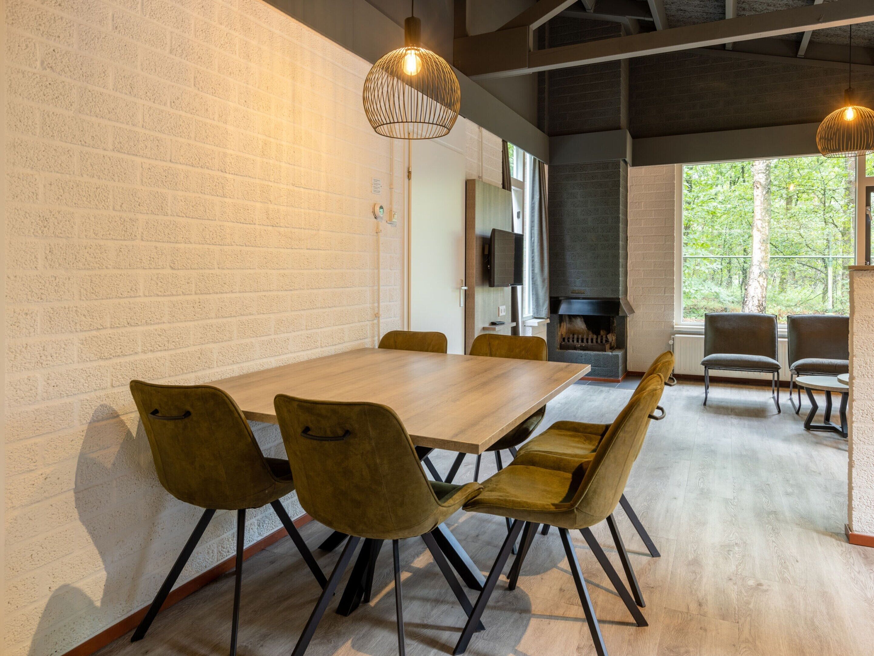 A modern dining area with a brick wall, a wooden table, and four chairs.