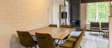 A modern dining area with a brick wall, a wooden table, and four chairs.