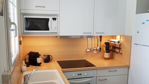 Une cuisine compacte équipée d’un four à micro-ondes, d’une cuisinière, d’un évier et d’un petit four.
