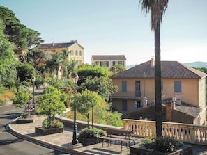 A residential area with a curved road, a bench, and a lamp post. - Holiday Home in Bormes Near Beaches & Pool (Bormes-Les-Mimosas)