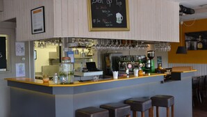 A bar area with a chalkboard menu, bar stools, and a coffee machine. - Bungalow in South Holland With Unique Design ('s-Gravenzande)