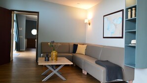 A modern living room with a sofa, a coffee table, and a bookshelf. - Bungalow in South Holland With Unique Design ('s-Gravenzande)