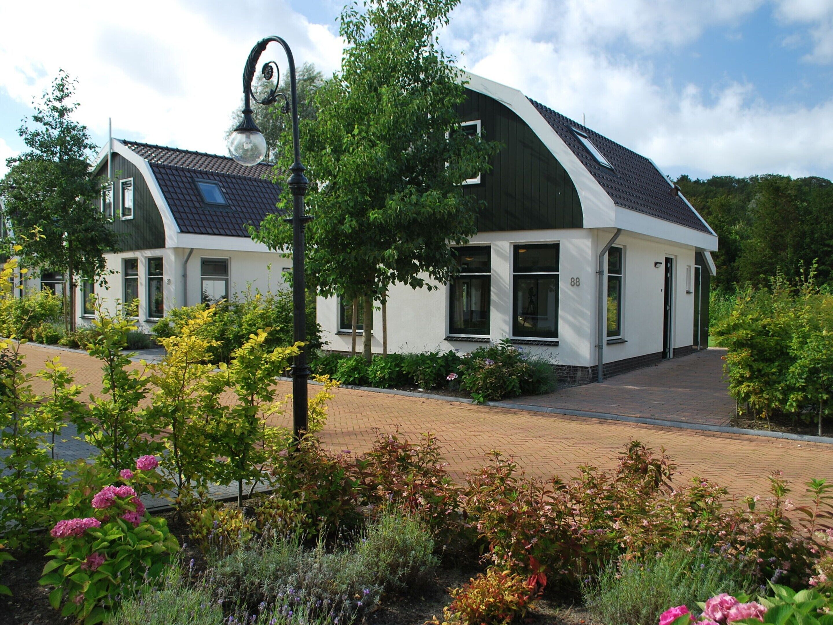 A modern building with a curved roof and a brick pathway leading to the entrance.