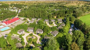 An aerial view of a residential area with houses, a swimming pool, and a large field. - Family Chalet in Netherlands Holiday Park (Egmond aan den Hoef)
