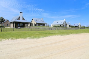 A rural property with multiple houses, a dirt road, and a wooden fence. - Villa Oesterdam Sleeps 10 Persons (Tholen)