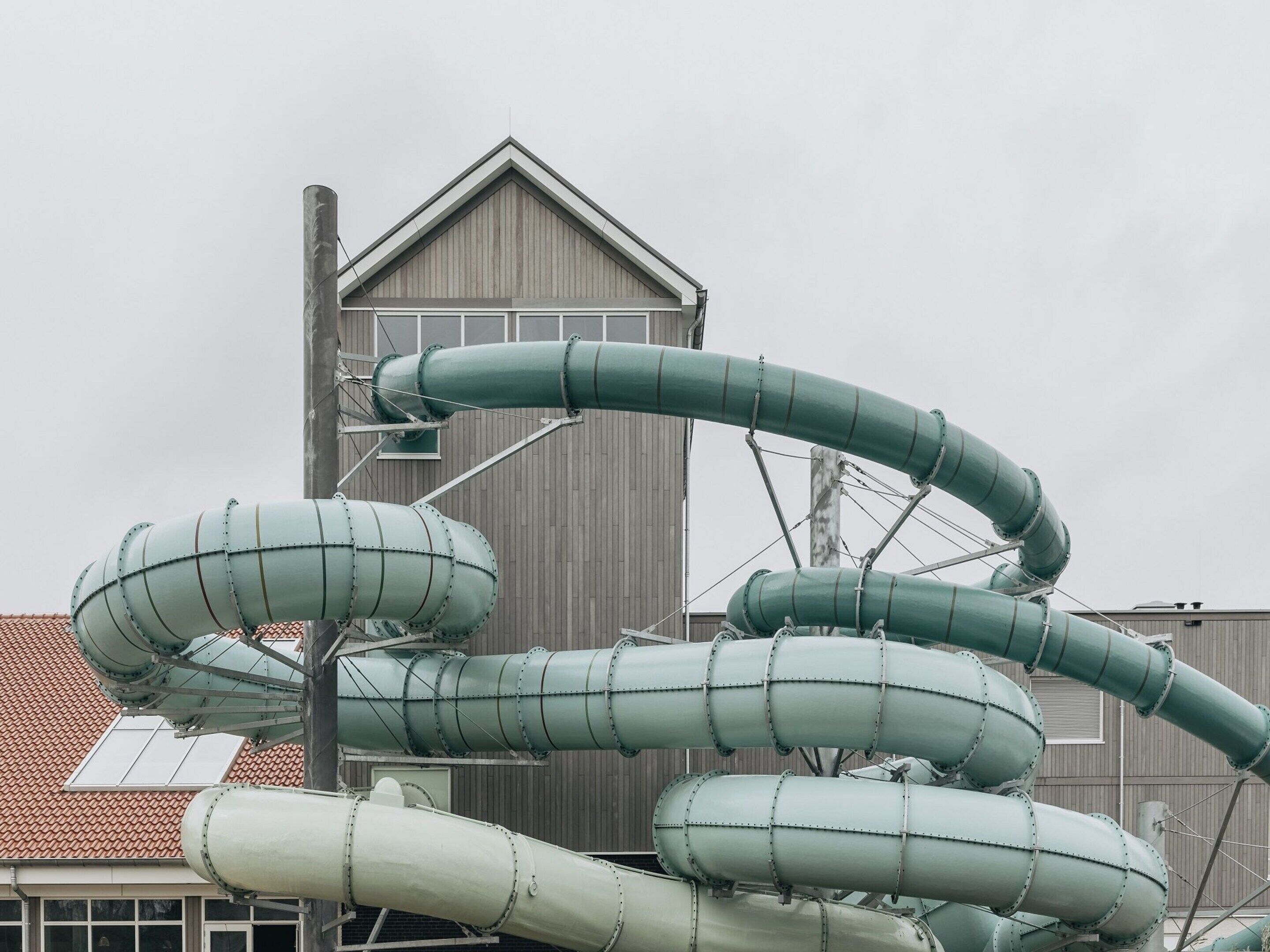 Une vaste structure industrielle, avec de nombreux tuyaux courbés et un grand bâtiment en arrière-plan.
