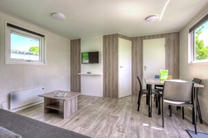 Ein modernes Zimmer mit Essbereich, Fernseher und Fenster mit Blick.