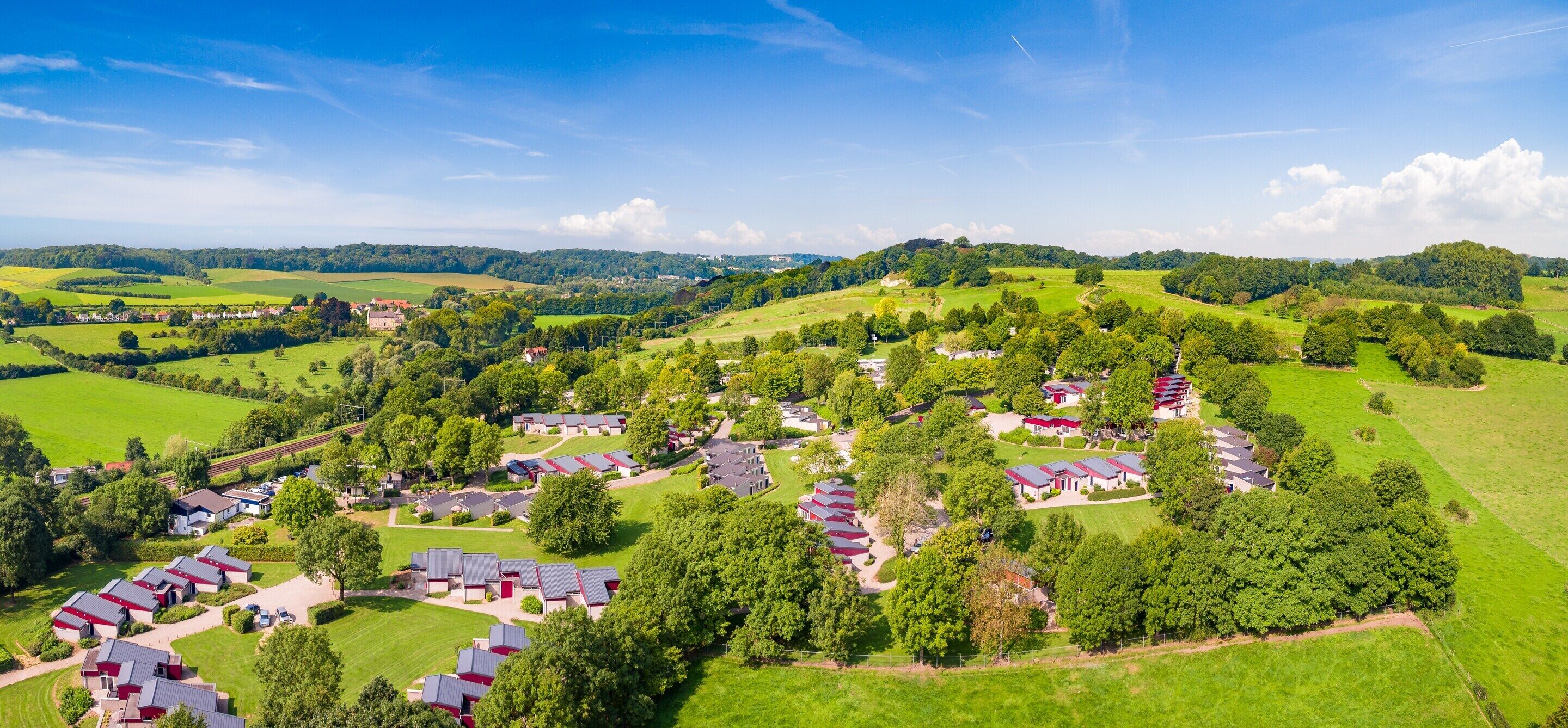 An aerial view of a residential area with multiple houses and a large green field.