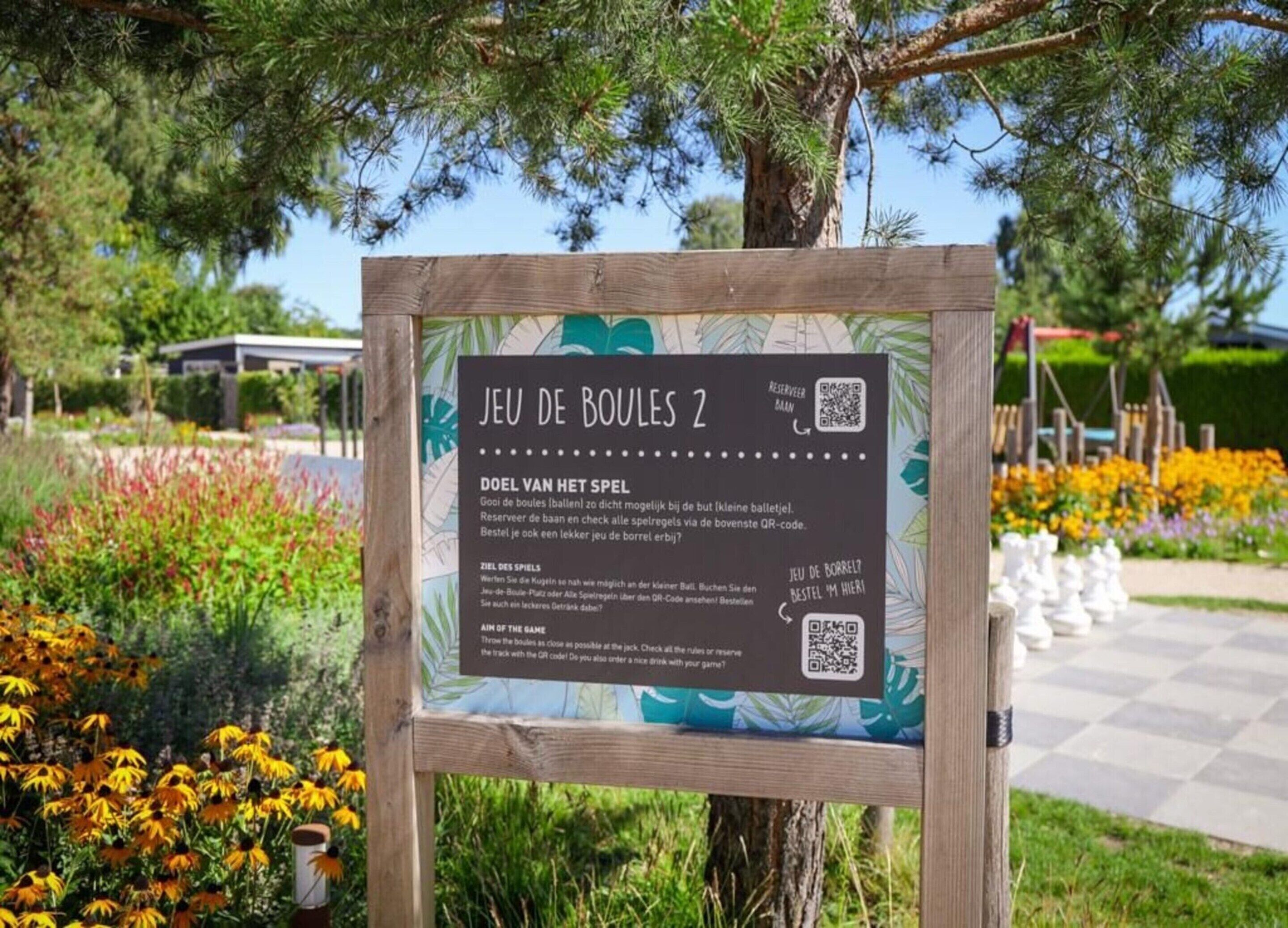 A sign for 'Jeu de Boules 2' with QR codes and instructions in Dutch.