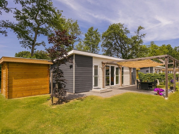 A single-story house with a garage, a covered patio, and a small garden area.