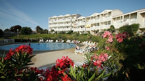 A hotel with a swimming pool, lounge chairs, and a landscaped garden. - Coastal Getaway With Pool (Fouras)