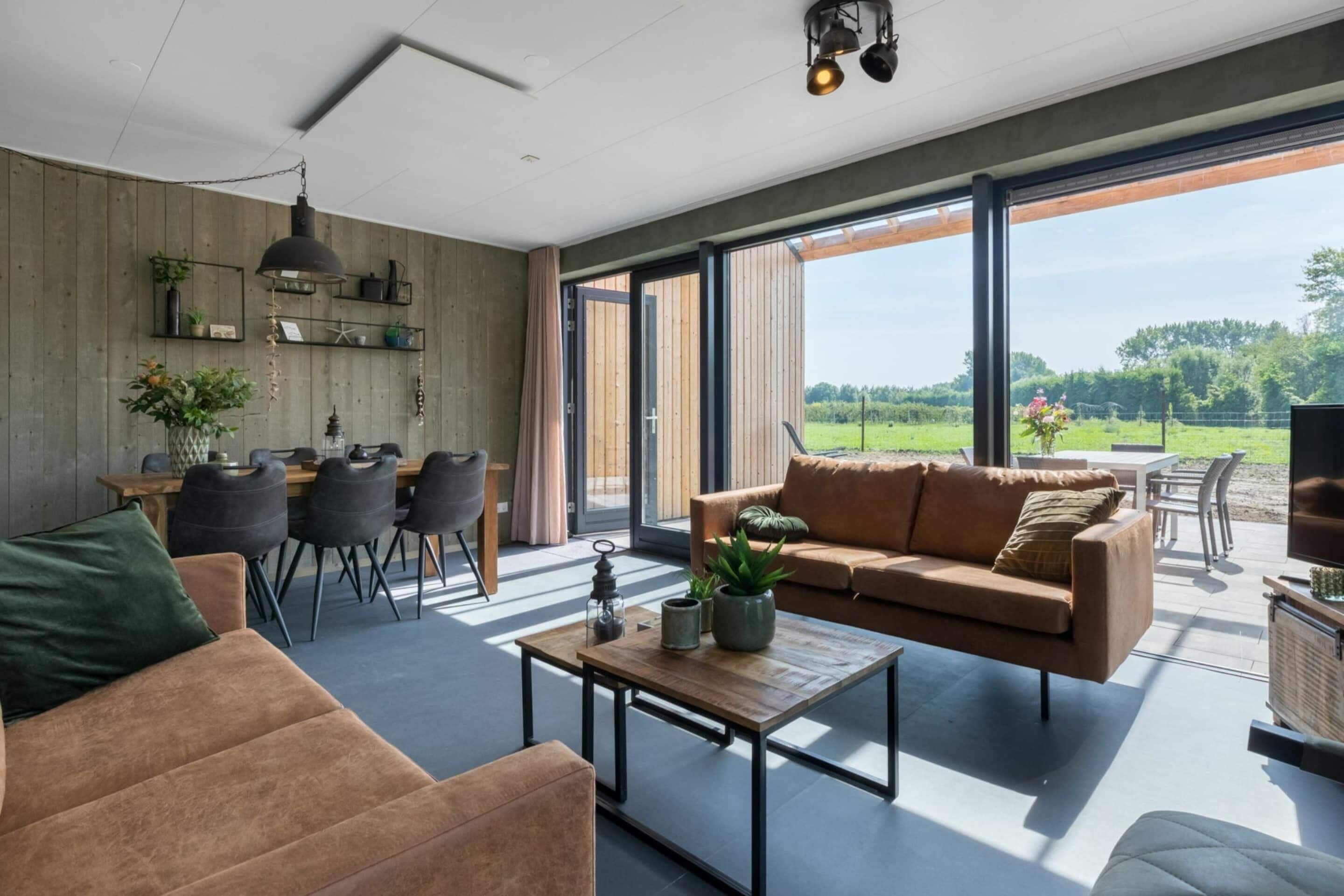 A modern living room with a large window, a sofa, a coffee table, and a dining area.