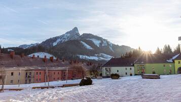 A snowy landscape with buildings and a mountain in the background.
