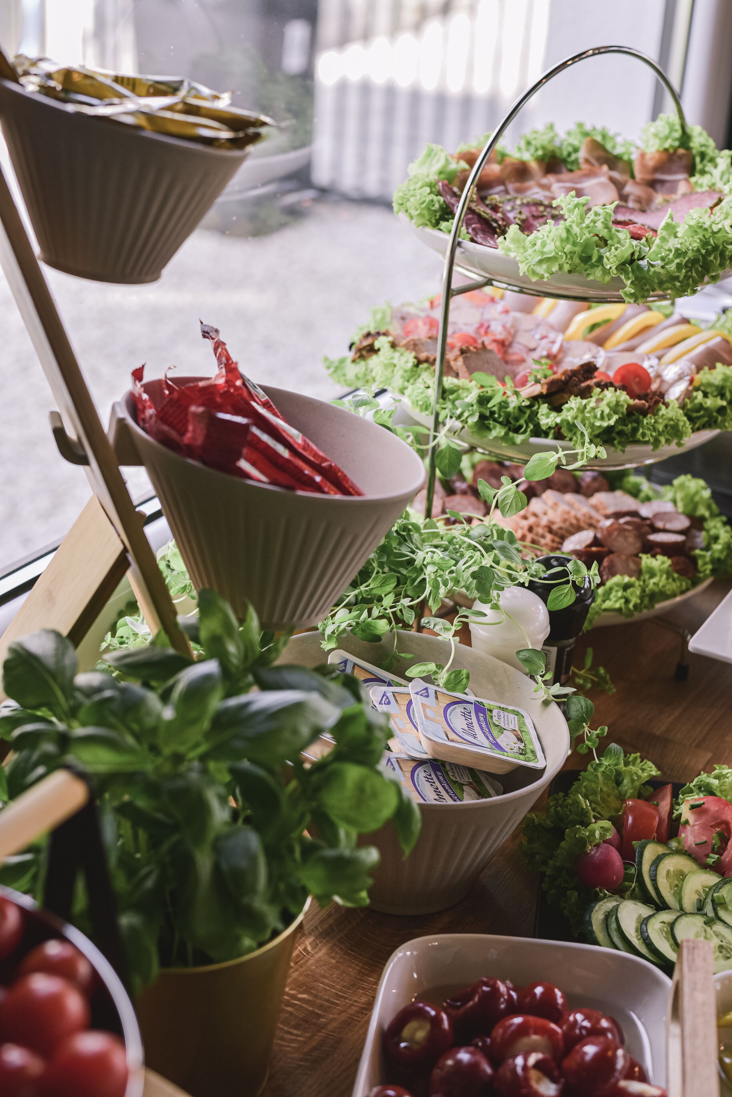 Una mesa de buffet con diversos alimentos y una planta en maceta.