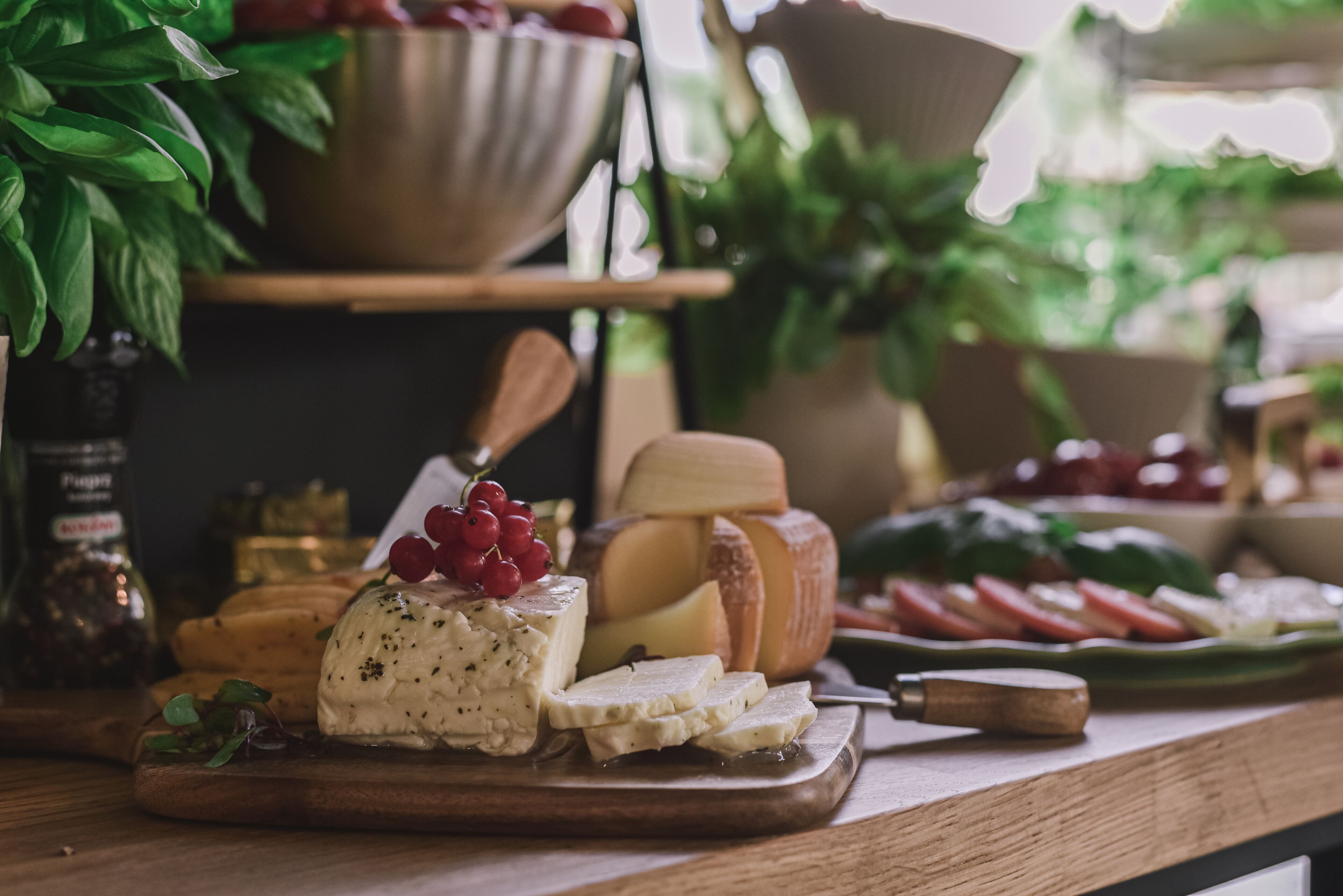 A variety of cheeses and fruits on a wooden board.