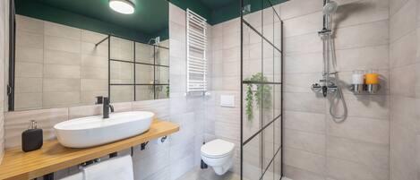 A modern bathroom with a large sink, toilet, and shower area.