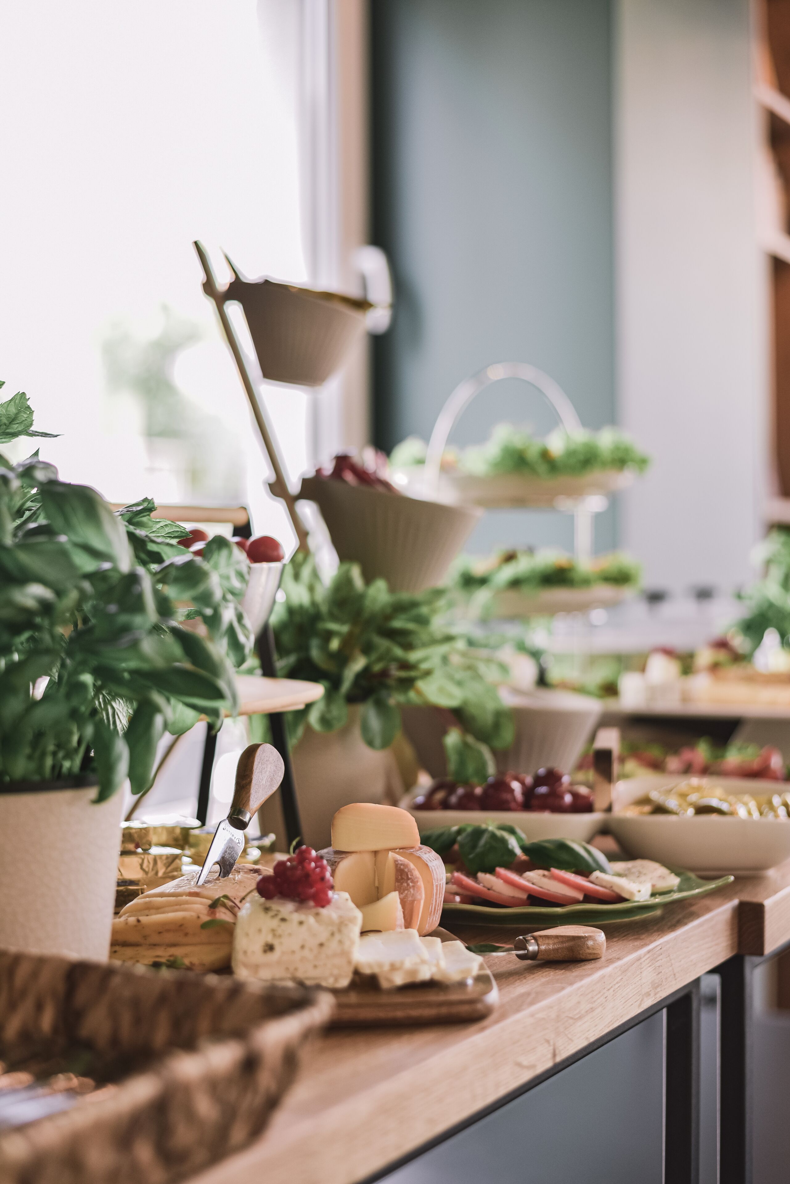 Ein reichhaltiges Buffet mit verschiedenen Käsesorten, Früchten und Gemüse.