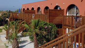 A building with arched windows, wooden balconies, and a palm tree. - Cap D'agde Retreat w/ Terrace (Agde)
