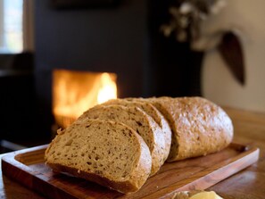Une miche de pain sur une planche à découper en bois, avec un arrière-plan flou.