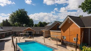 Une piscine entourée de bâtiments, avec un ciel dégagé.