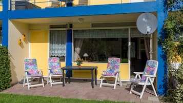 Een gebouw met twee verdiepingen, een balkon, een terras en een schotelantenne.