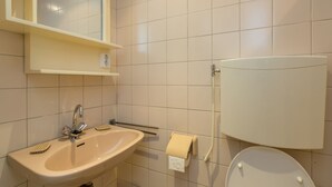 Een badkamer met een wastafel, spiegel en toilet.
