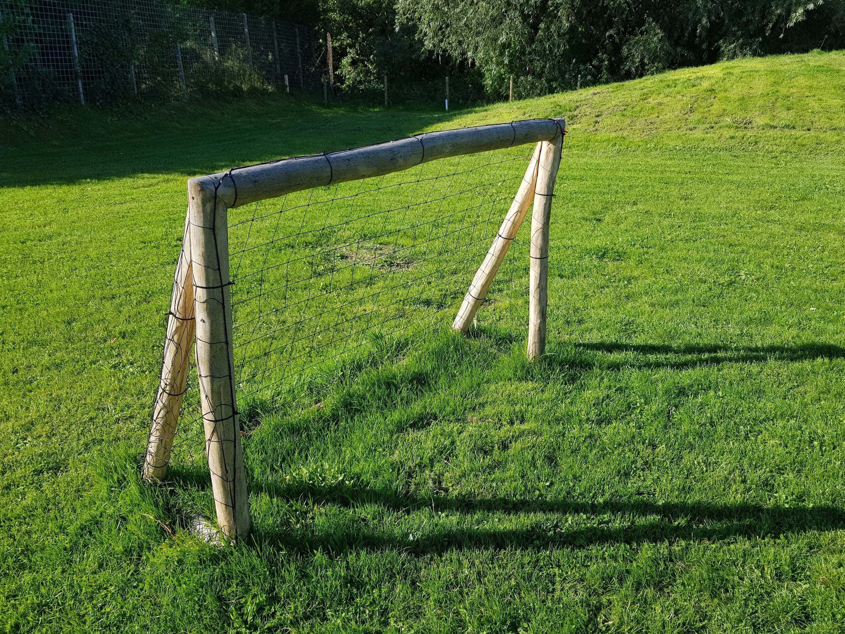 Una estructura de madera sencilla en un campo cubierto de hierba.