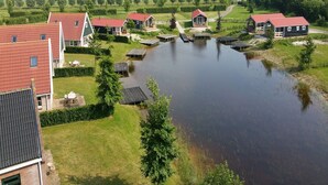 A residential area with houses, a pond, and a pathway.