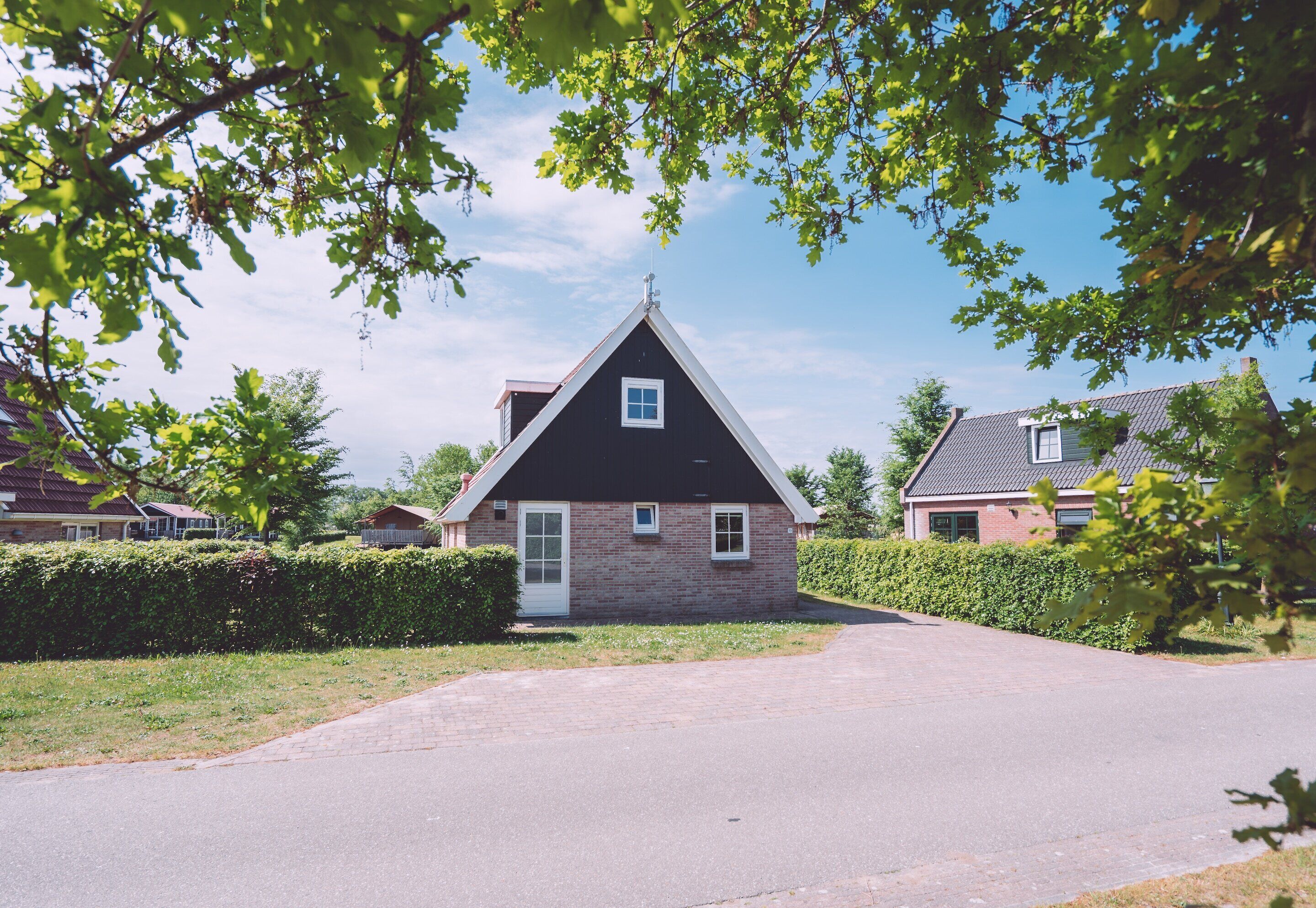 A single-story house with a gabled roof, a front door, and a small window.