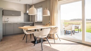 Una cocina moderna con comedor, ventanas amplias y vistas al exterior.