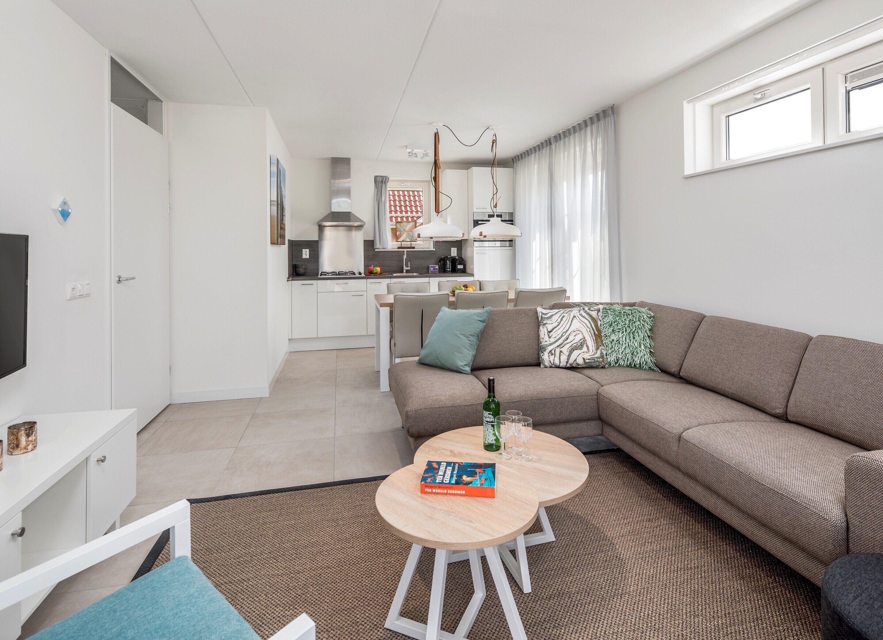 Un appartamento moderno con soggiorno, cucina e zona pranzo.