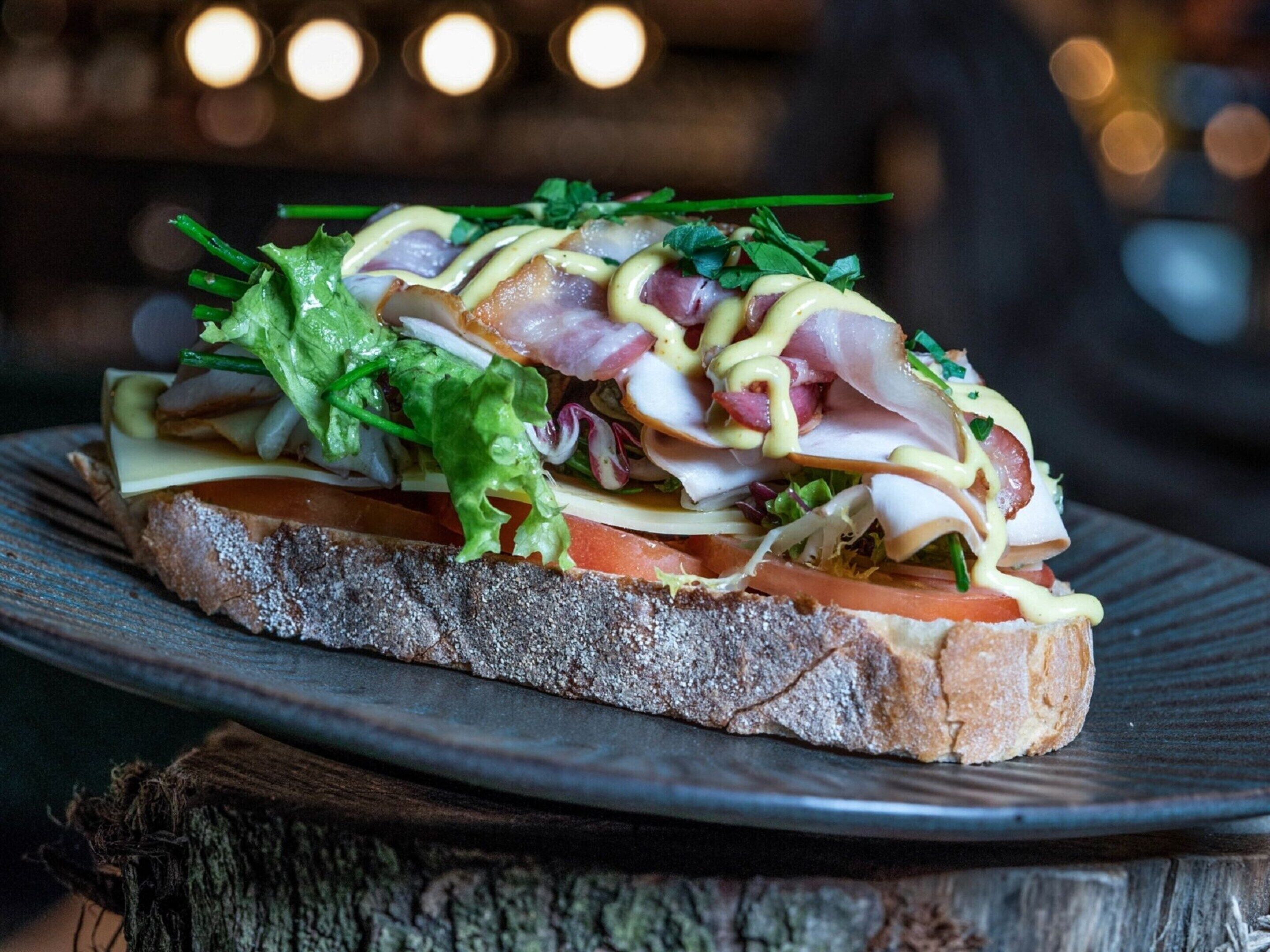 A sandwich on a plate with a rustic wooden background.