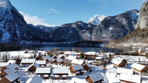 A snow-covered village with wooden houses, a lake, and mountains in the background. - Apartment in Obertraun Near Dachstein Ski Area (Obertraun)