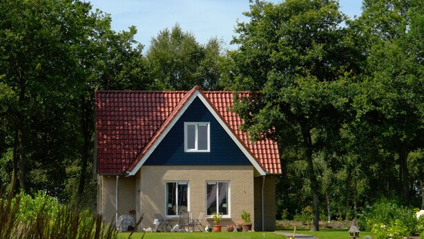 A house with a red-tiled roof, a small front porch, and a pond in front. - Holiday Home With Dishwasher, 20 km From Assen (Westerbork)