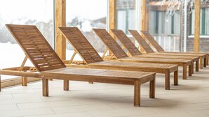 A row of wooden lounge chairs with metal frames, arranged in a sunroom with large windows and a tiled floor. - Spacious Chalet near Ski Area in Sankt Georgen ob Murau (Sankt Georgen am Kreischberg)