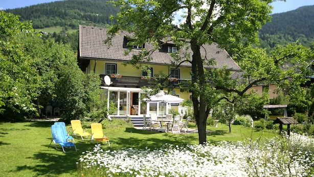 A house with a garden, a patio with outdoor furniture, and a view of the surrounding landscape. - Cozy Apartment in Feld am See near Ski Slopes (Feld am See)