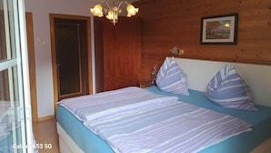 A bedroom with a bed, wooden panel walls, a chandelier, and a framed picture. - Cozy Apartment in Feld am See near Ski Slopes (Feld am See)