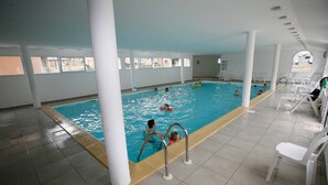 An indoor swimming pool with clear water, white columns, and a tiled floor. - Brittany Retreat w/ Pool (Le Tronchet)