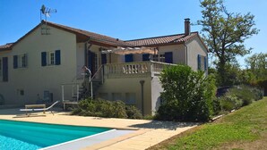 Une maison à deux étages dotée d’une piscine, d’un balcon et d’un escalier menant à l’étage supérieur.