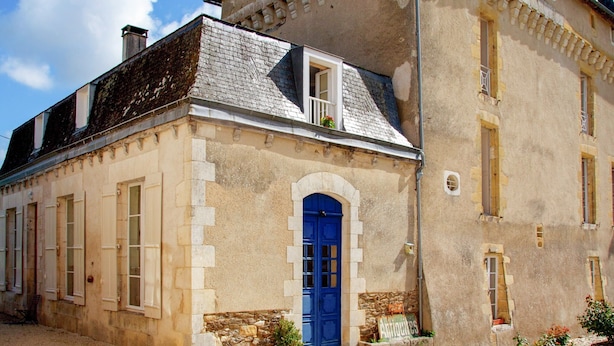 A historic building with a prominent blue door, stone steps, and a balcony. - Cottage in Chaleix Near Forest & Lake (Chalais)