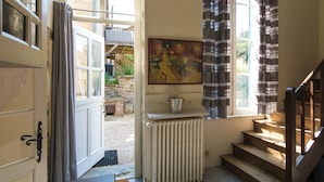 A room with a wooden staircase, a radiator, and a painting on the wall. - Cottage in Chaleix Near Forest & Lake (Chalais)