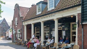 A café with outdoor seating, brick walls, and a tiled roof. - Comfortable Flat in Bergen (Bergen)