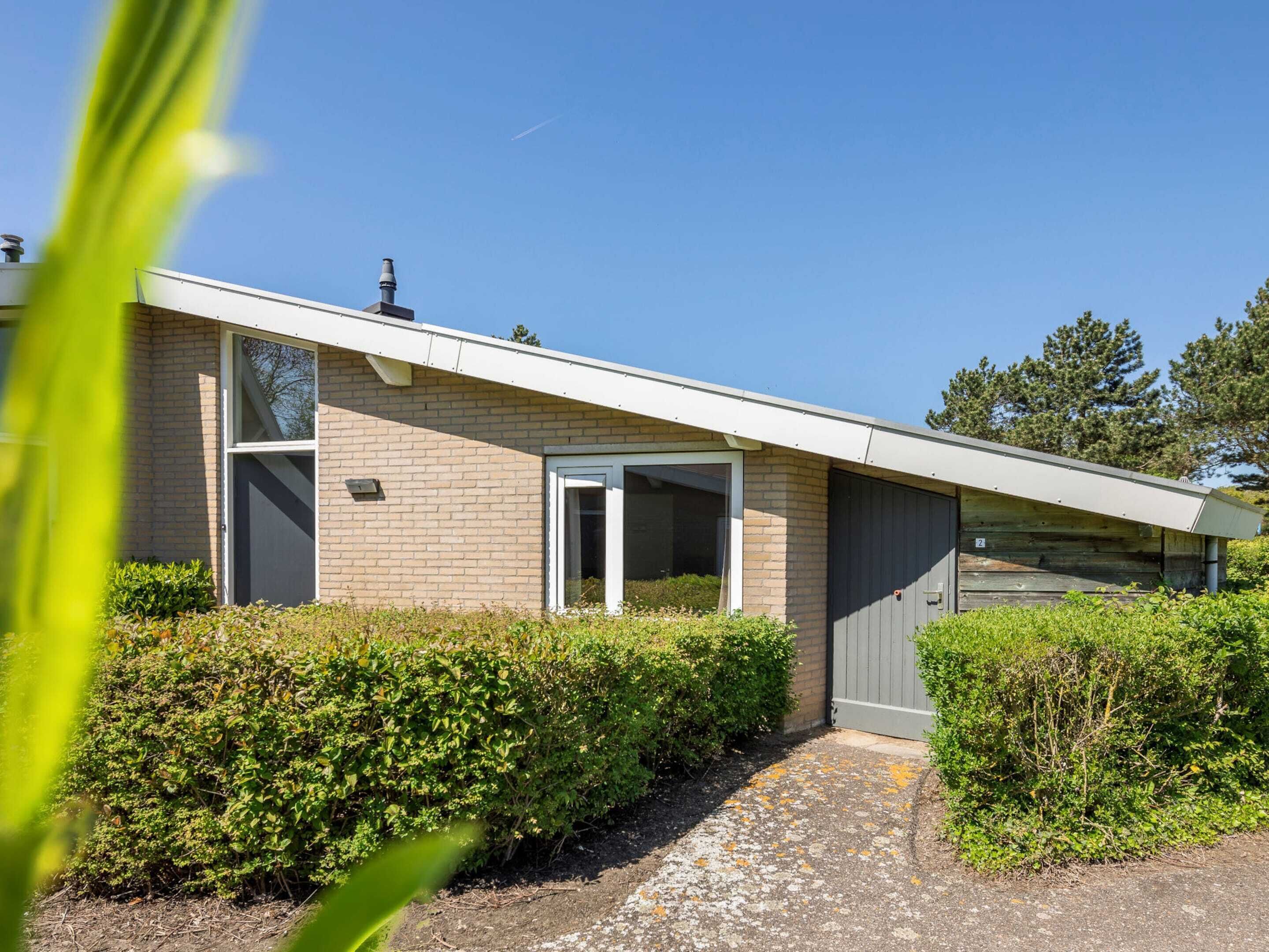 A modern house with a sloped roof, a garage, and a well-maintained garden.