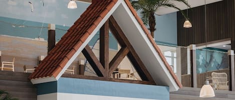 A model of a house with a sloped roof and a striped facade.